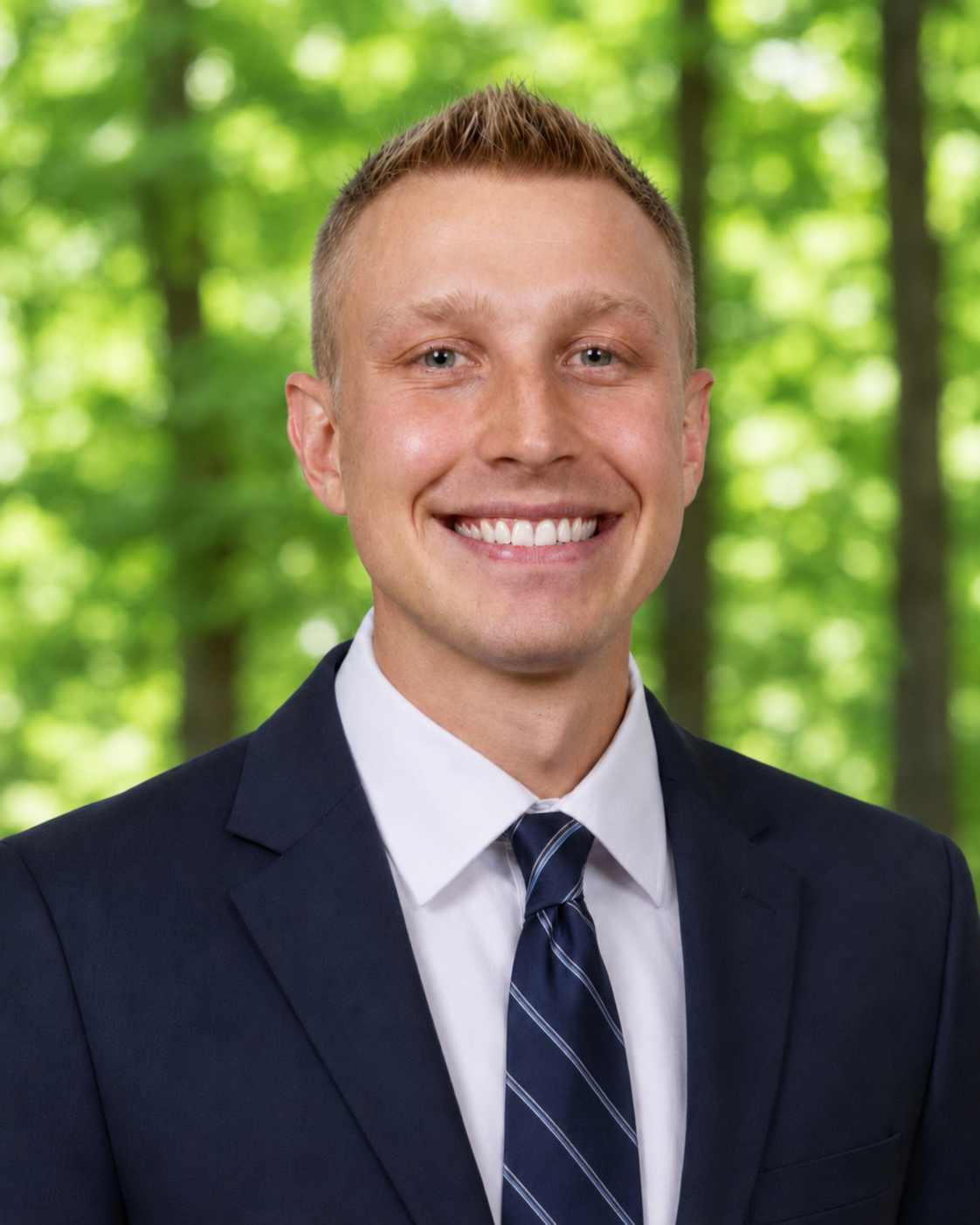 Dr. Alec Thurston Phot of Dr. Alec Thurston smiling while wearing a blue suit and tie